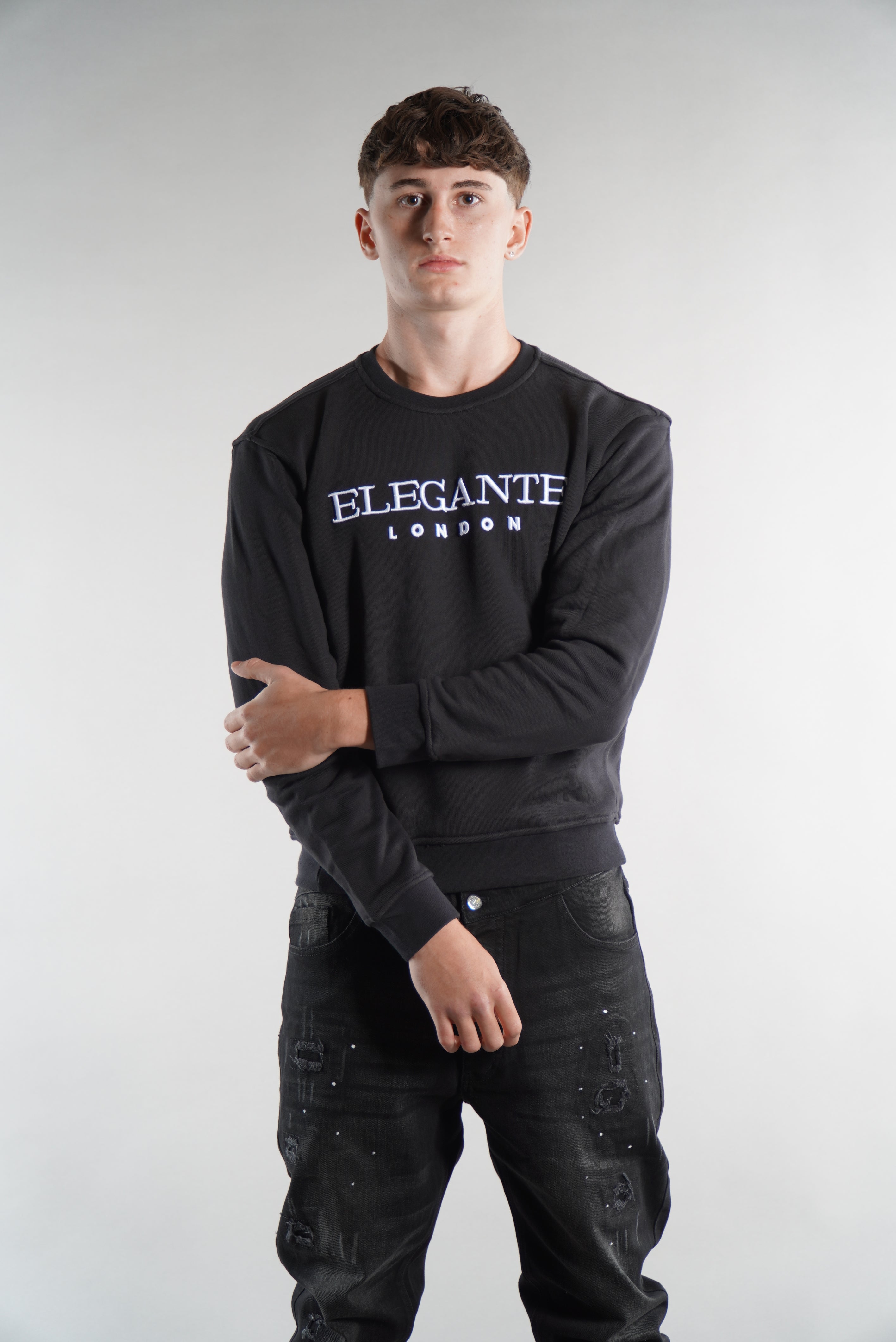 man wearing black jumper/sweatshirt with Elegante Logo on across chest