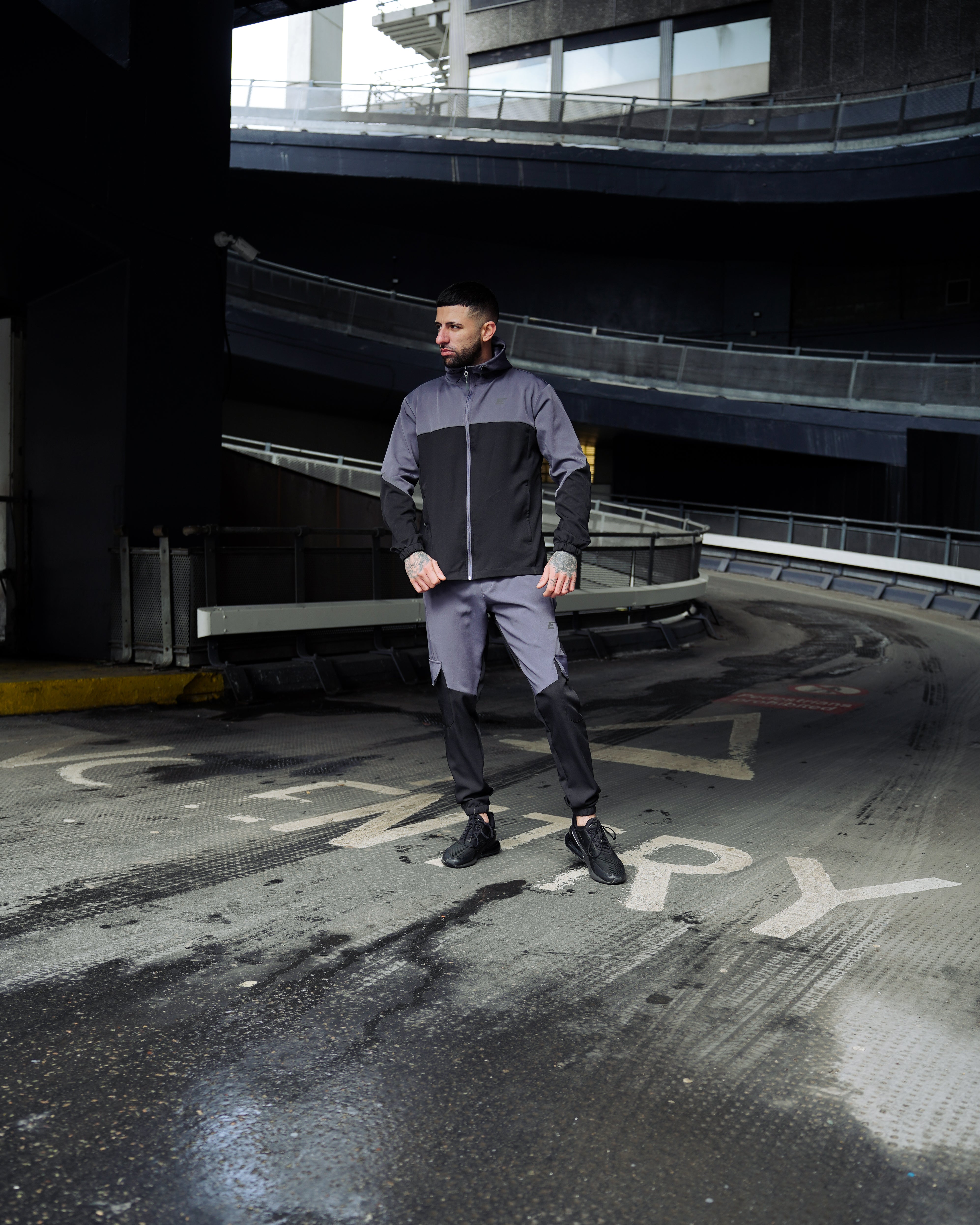 Man wearing Grey and Black Tracksuit with Elegante Logo on chest