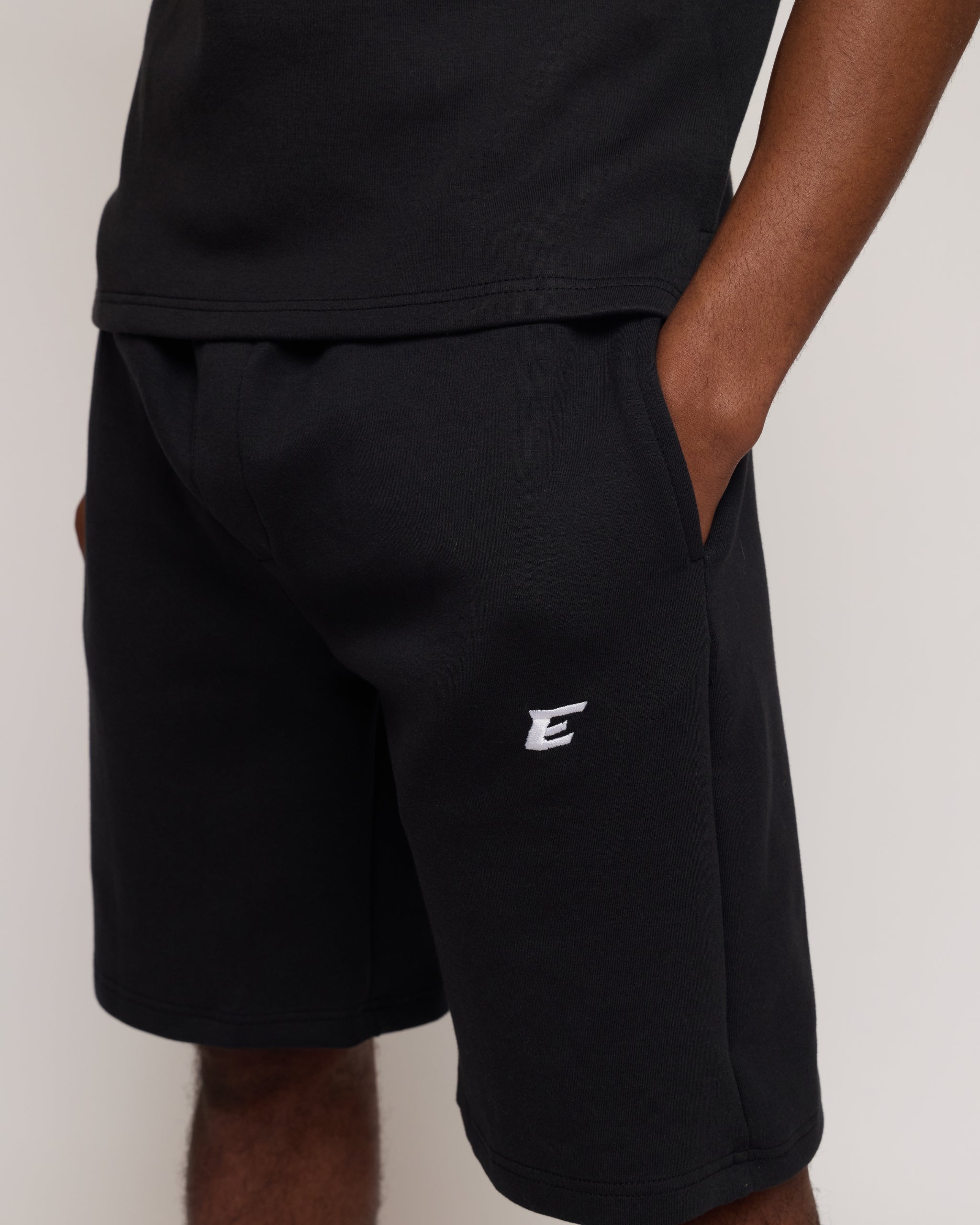 Man wearing a black shorts with 'E' brand logo on a white background