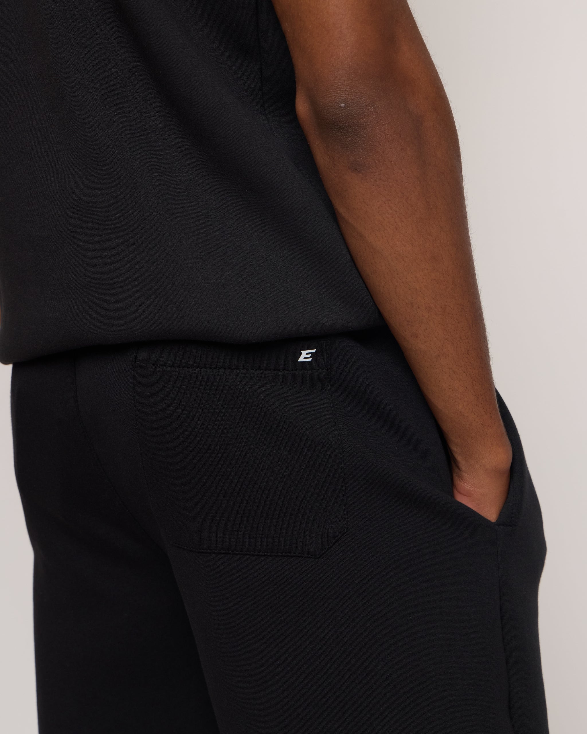 Man wearing a black shorts with 'E' brand logo on a white background