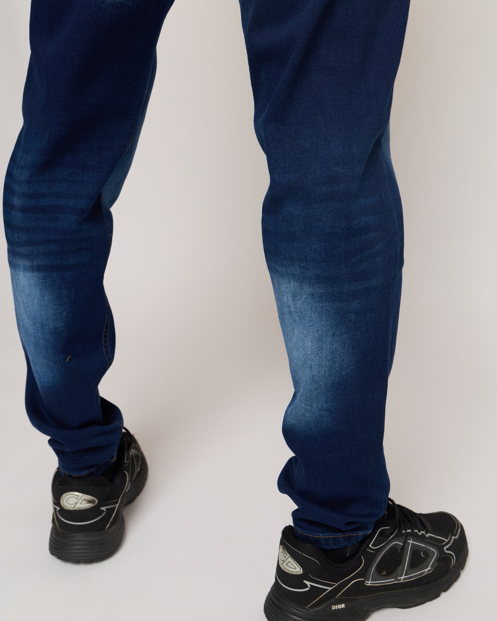 Blue jeans worn by a person on a white background