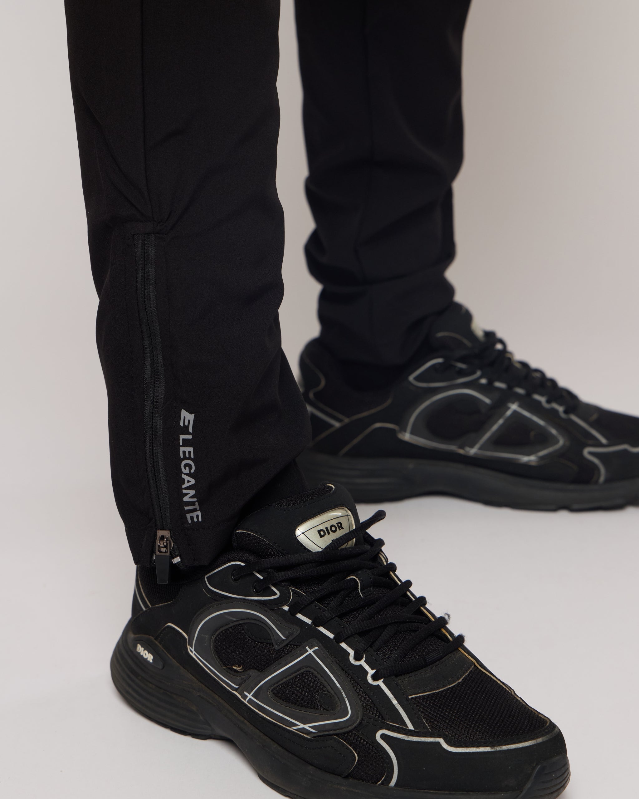 Black sneakers with visible brand logos on a light gray background