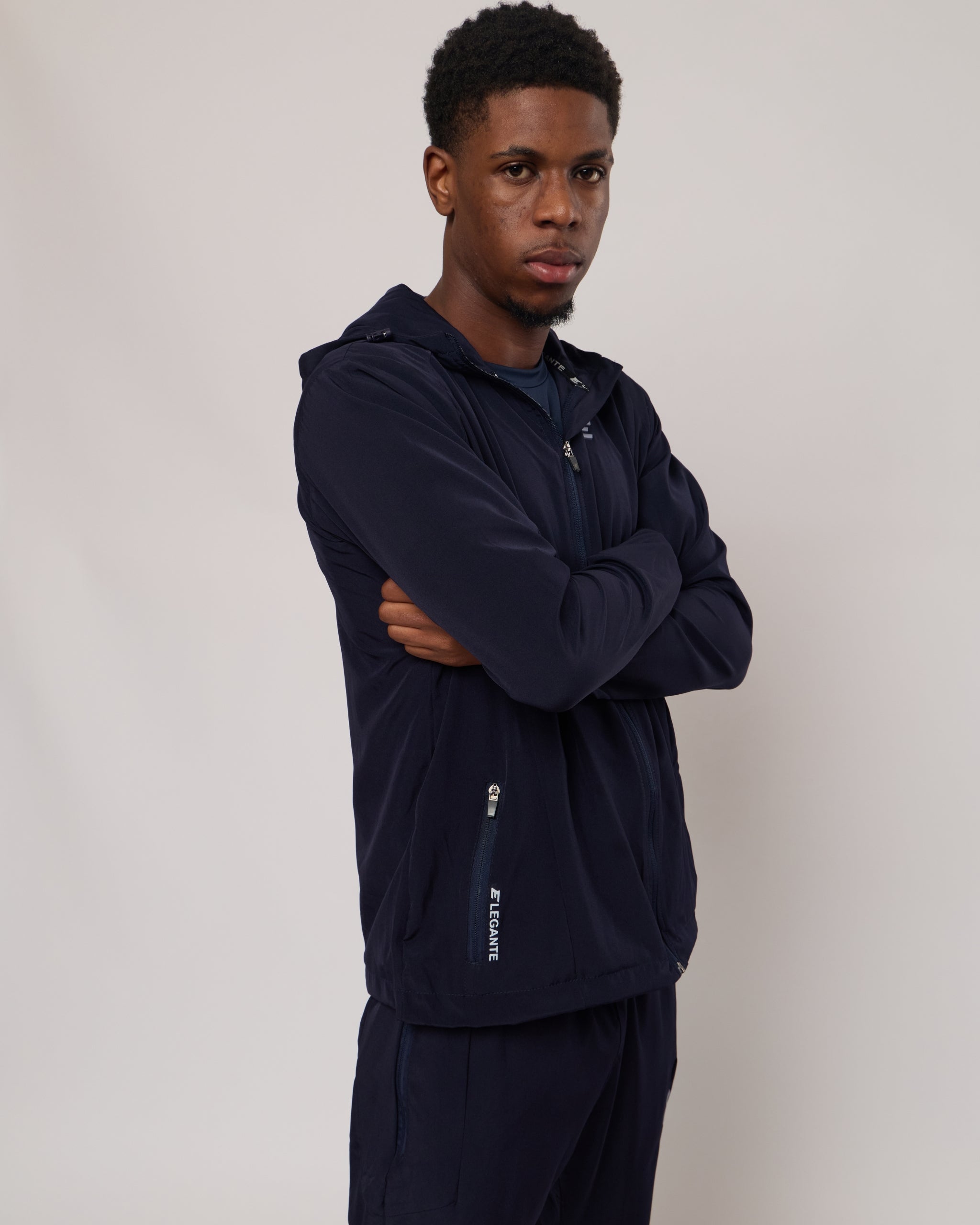 man wearing a full black tracksuit set with 'Elegante' branding on a white background