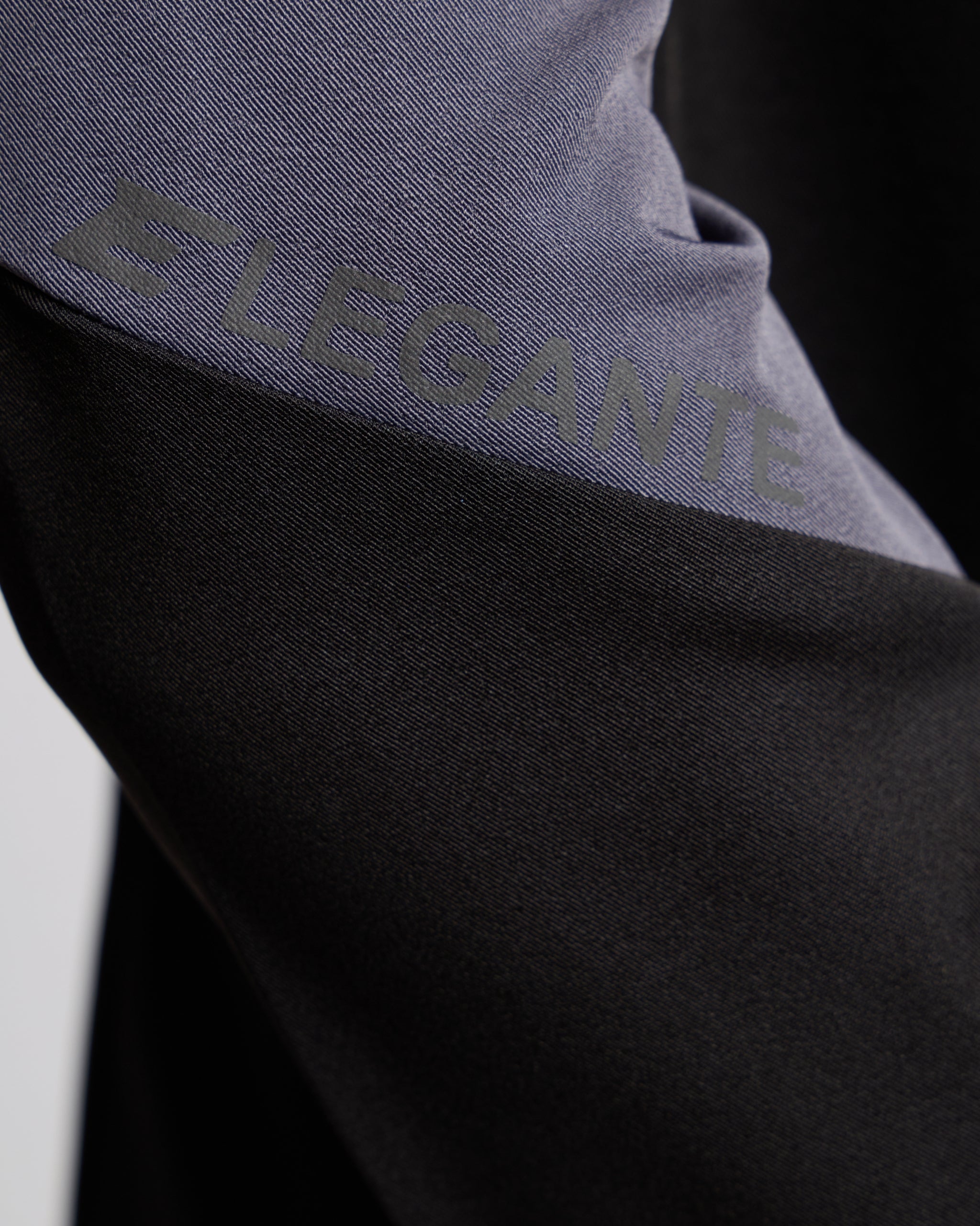 Close-up of a black and gray fabric with 'Elegante' branding.