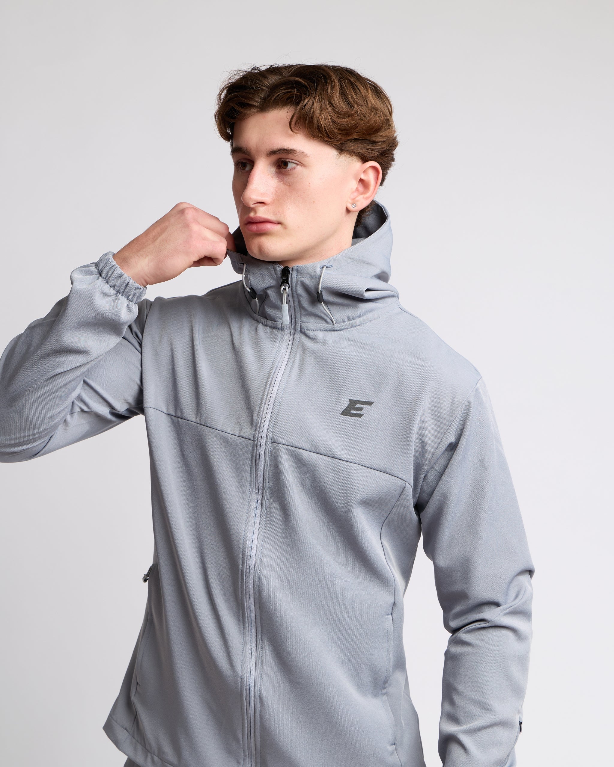 Man wearing a gray jacket with elegante brand logo on a light gray background