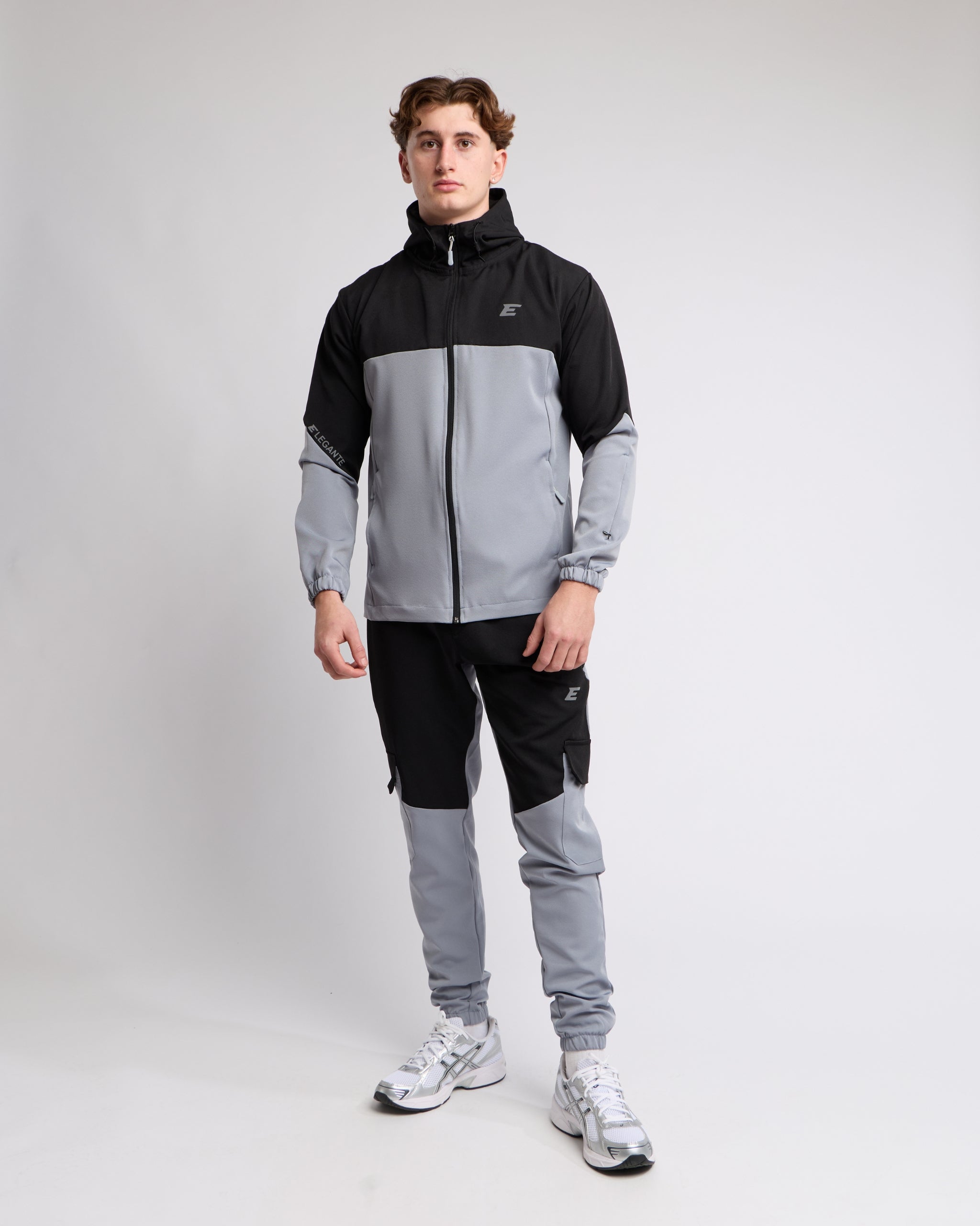 elegante wearing a black and gray tracksuit with a elegante brand logo on a light gray background