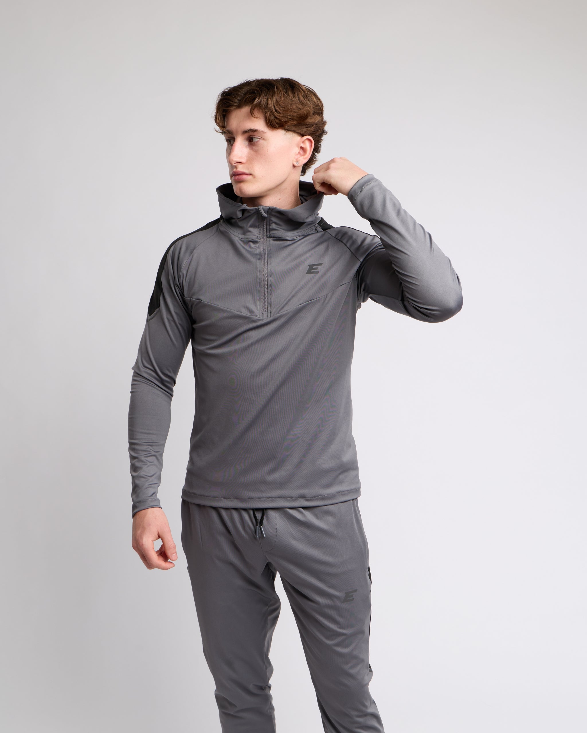 man wearing a gray tracksuit set on a light gray background