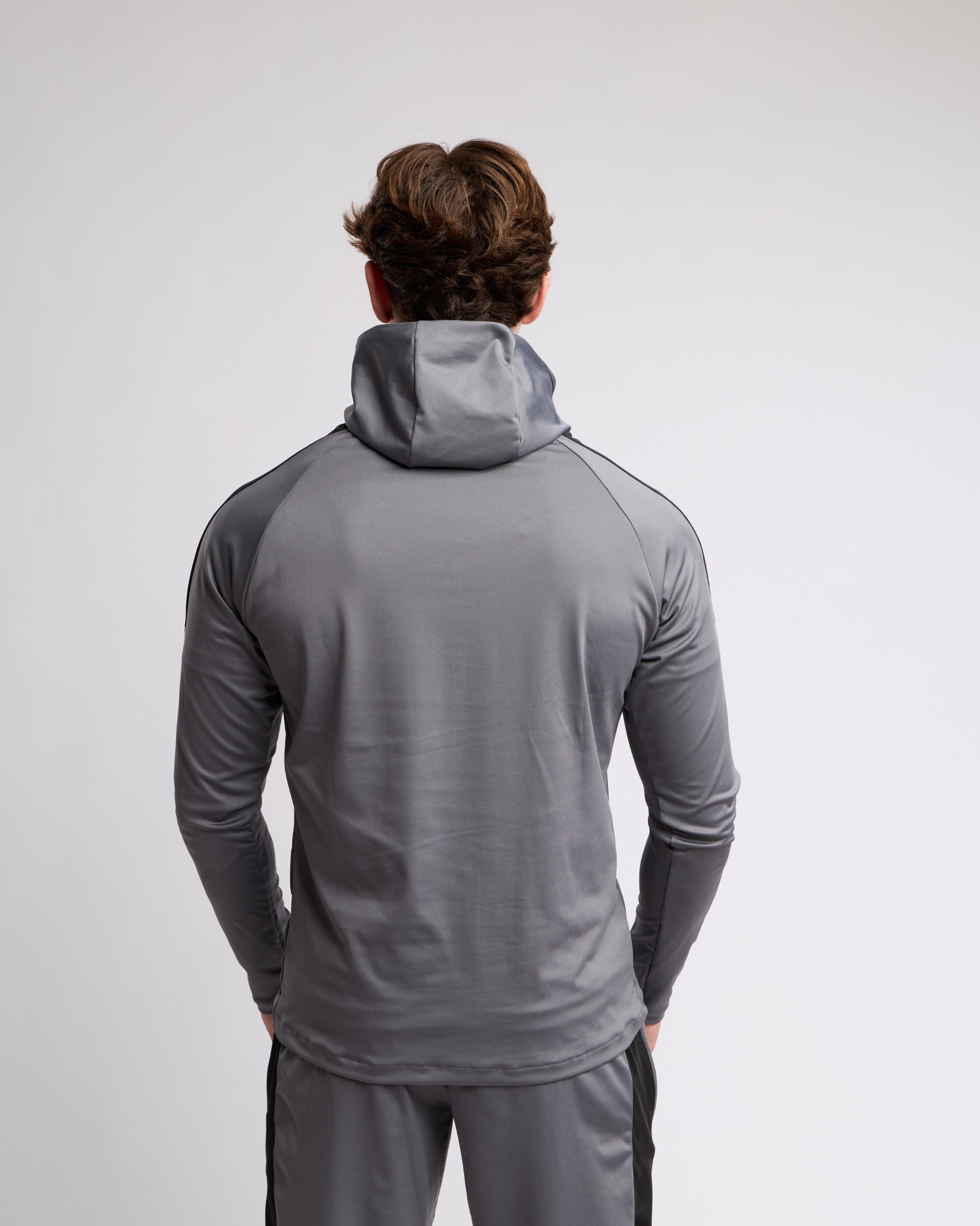 Person wearing a gray athletic outfit on a light gray background