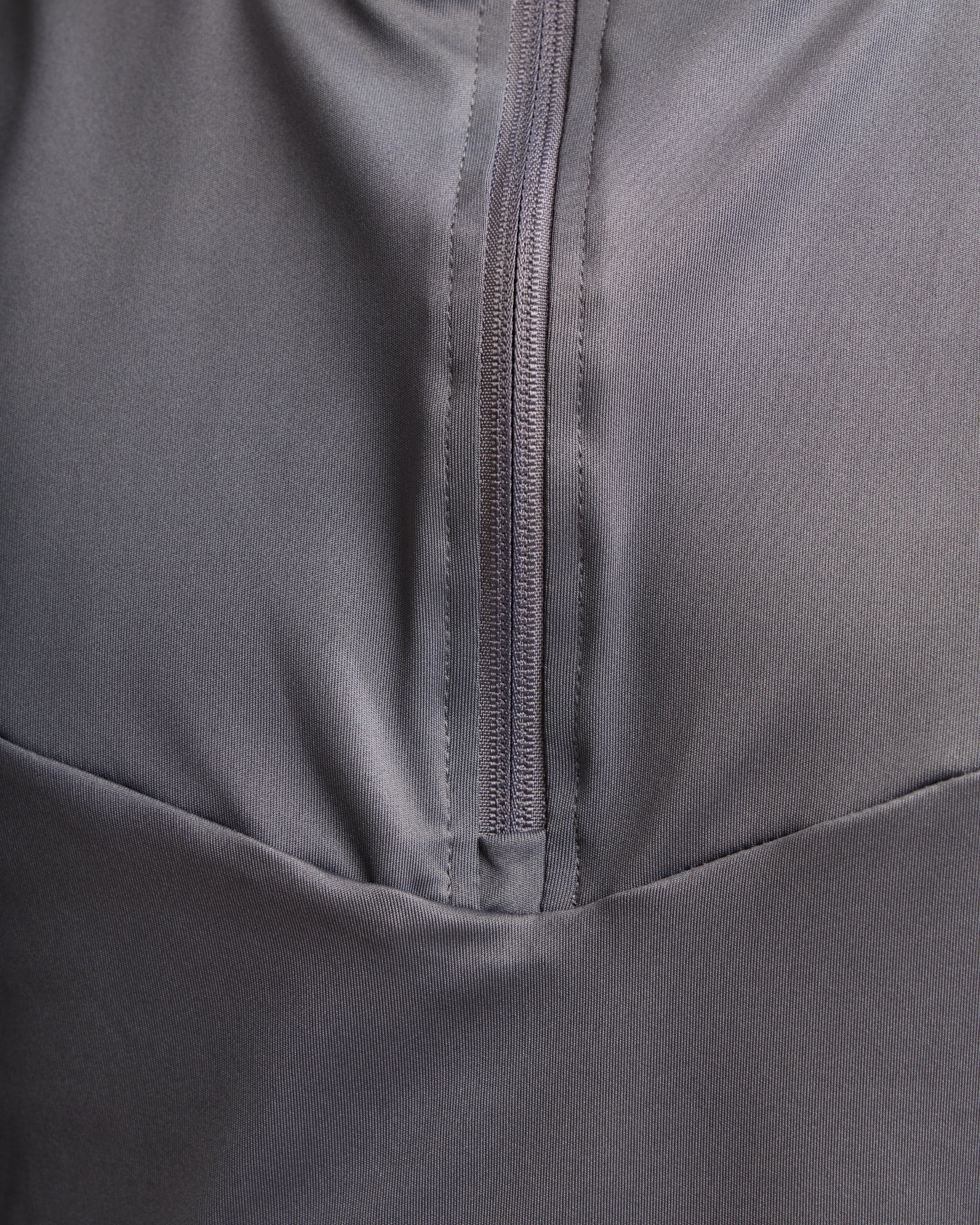 Close-up of a gray jacket with a zipper detail