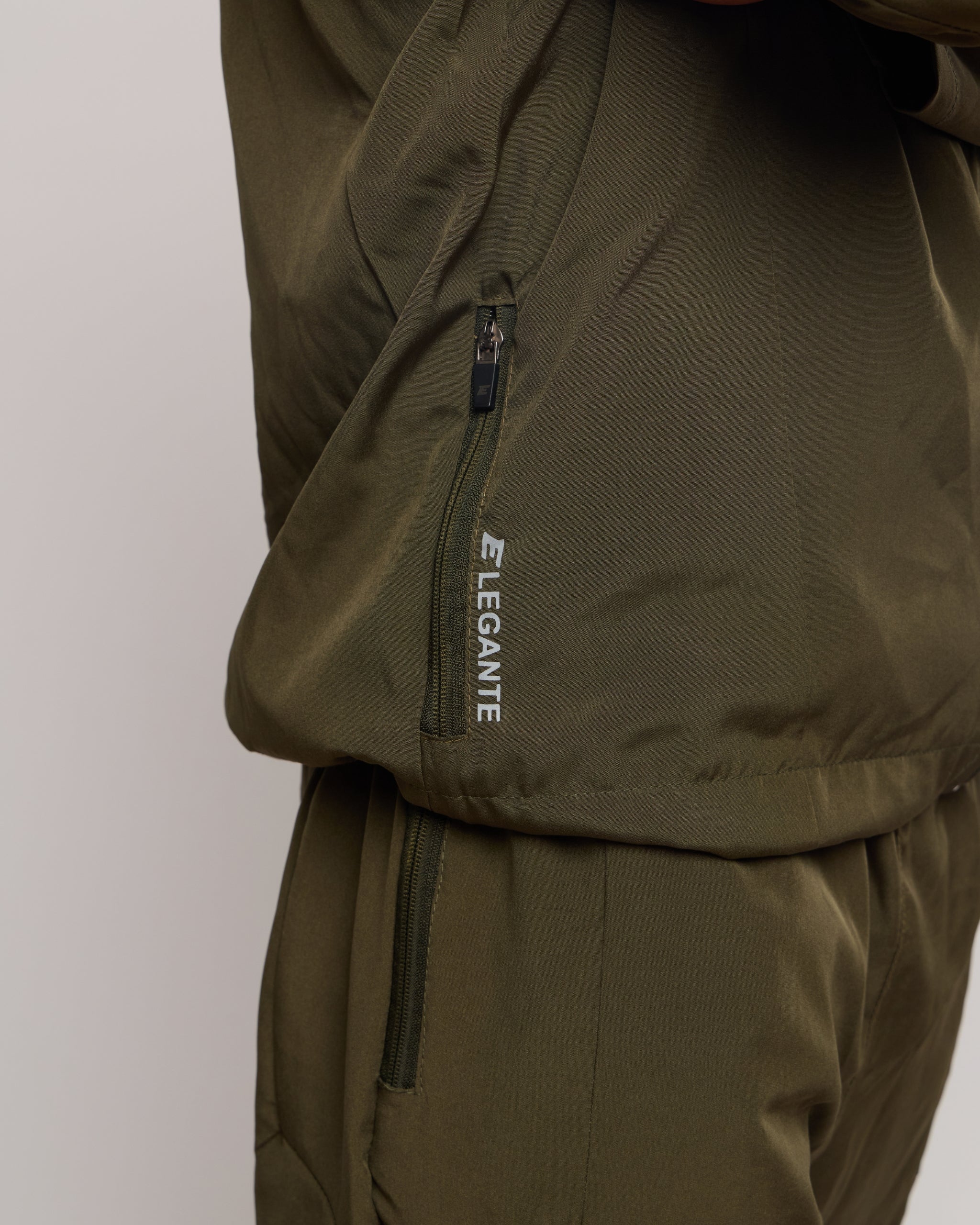 Green jacket with 'ELEGANTE' branding on a light gray background