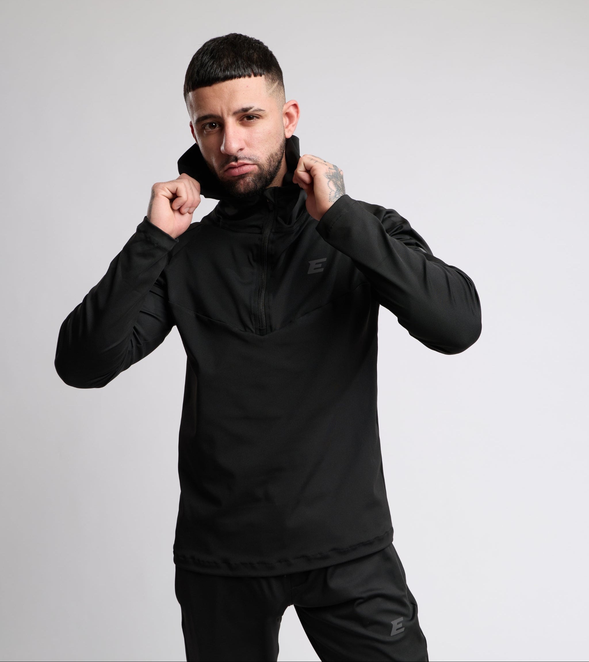 Man wearing a black jacket against a gray background