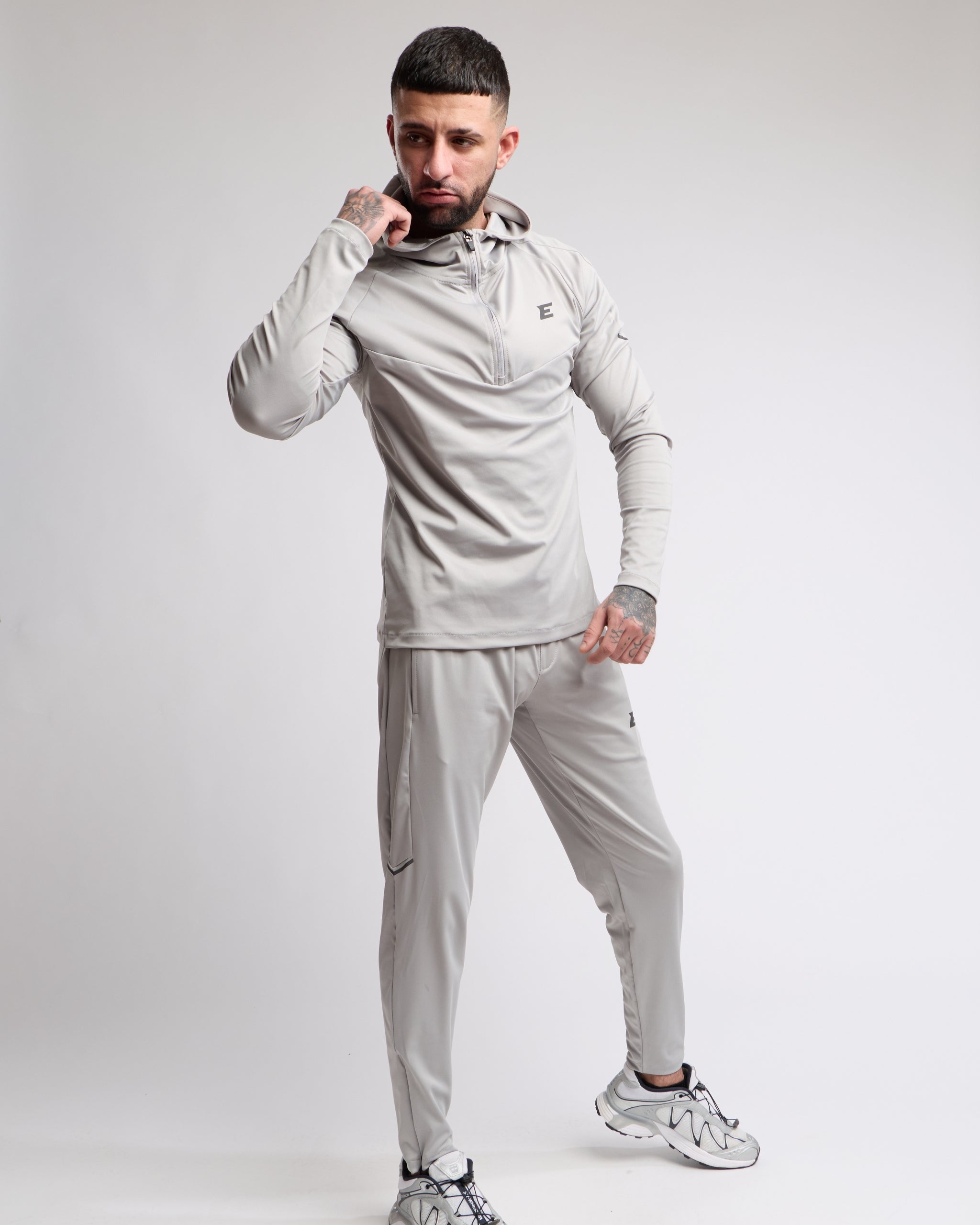 Man wearing a gray tracksuit on a white background