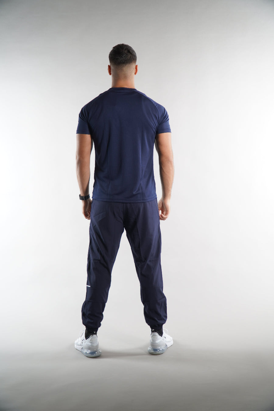 Man wearing Elegante gym T-Shirt in navy, with navy tracksuit joggers