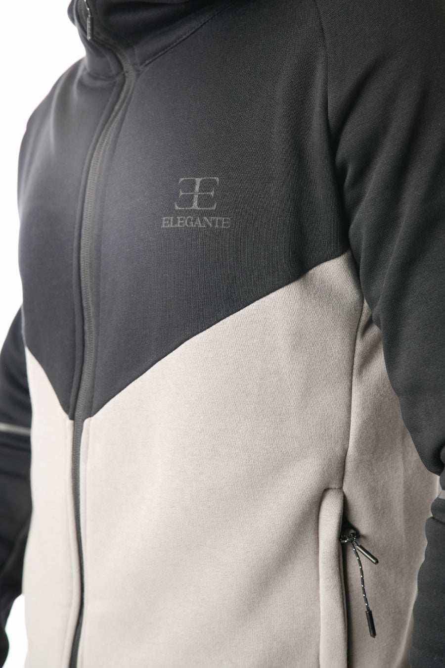 Two-tone jacket with dark gray and beige sections, featuring the Elegante logo.