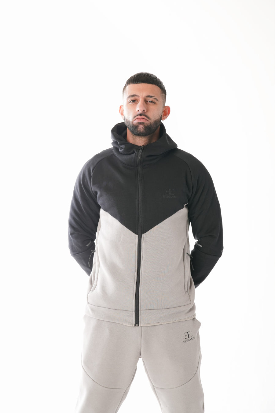 Man wearing a black and gray tracksuit on a white background