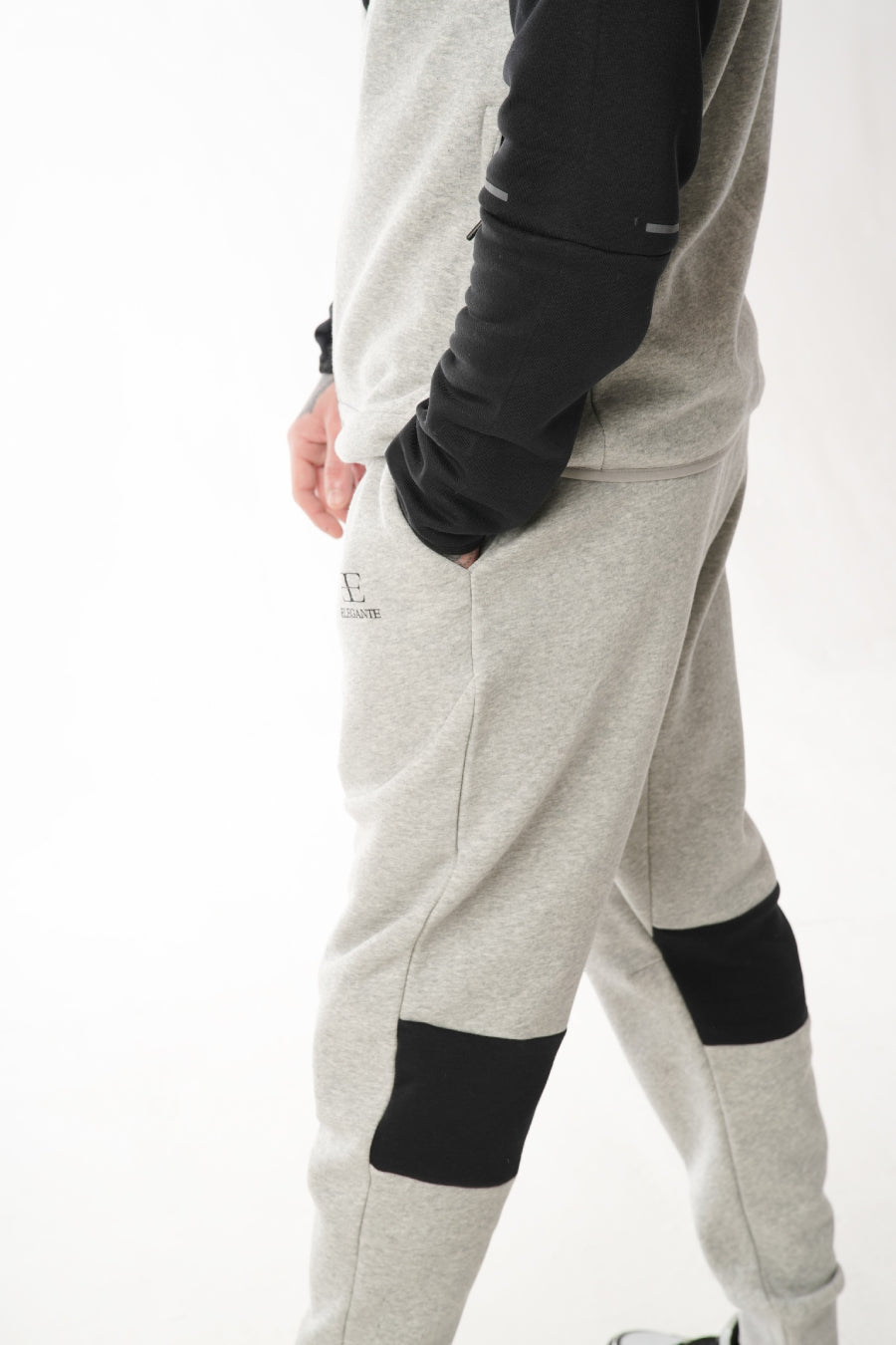 Grey jogger pants with black accents on a white background