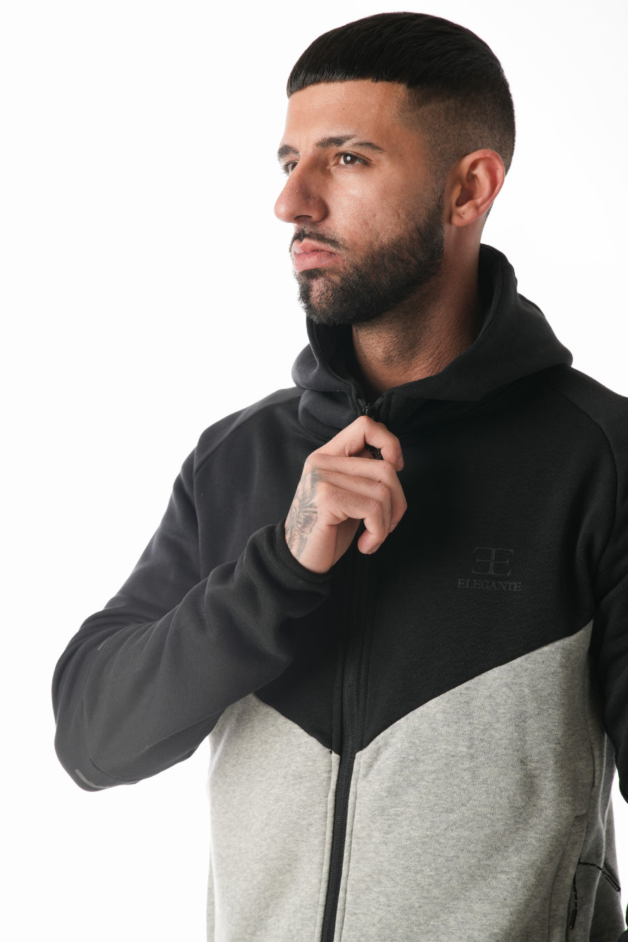 Man wearing a black and gray jacket with a brand logo on a white background