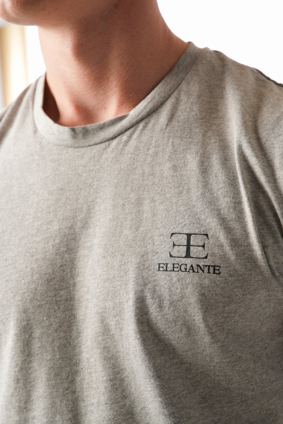 Gray t-shirt with 'Elegante' logo on a plain background