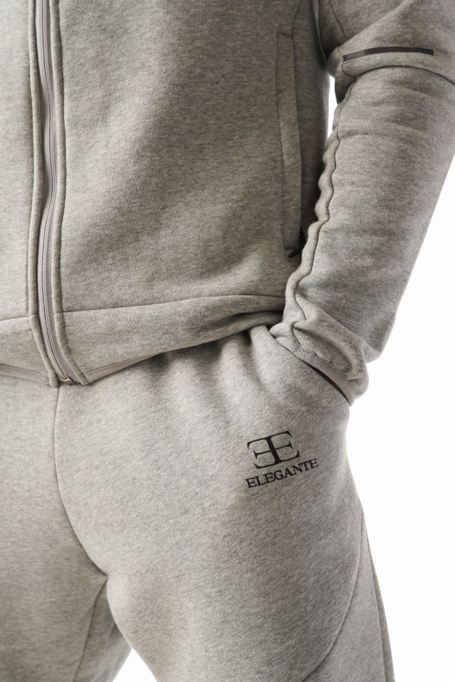 Gray tracksuit with elegante brand logo on the leg against a white background