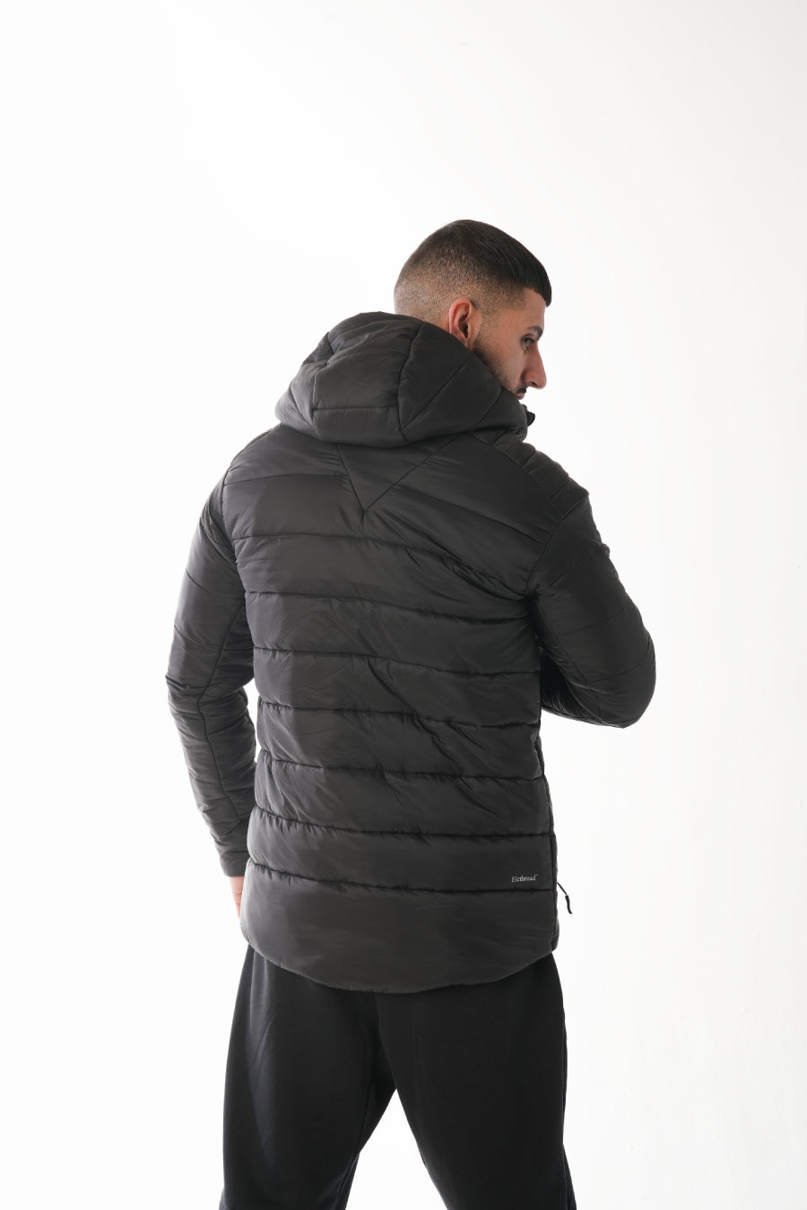 Man wearing a black puffer jacket on a white background