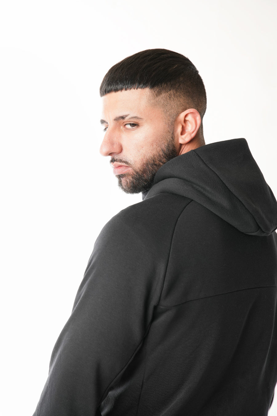 Man wearing a black hoodie against a white background