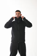 Man wearing a black tracksuit against a white background