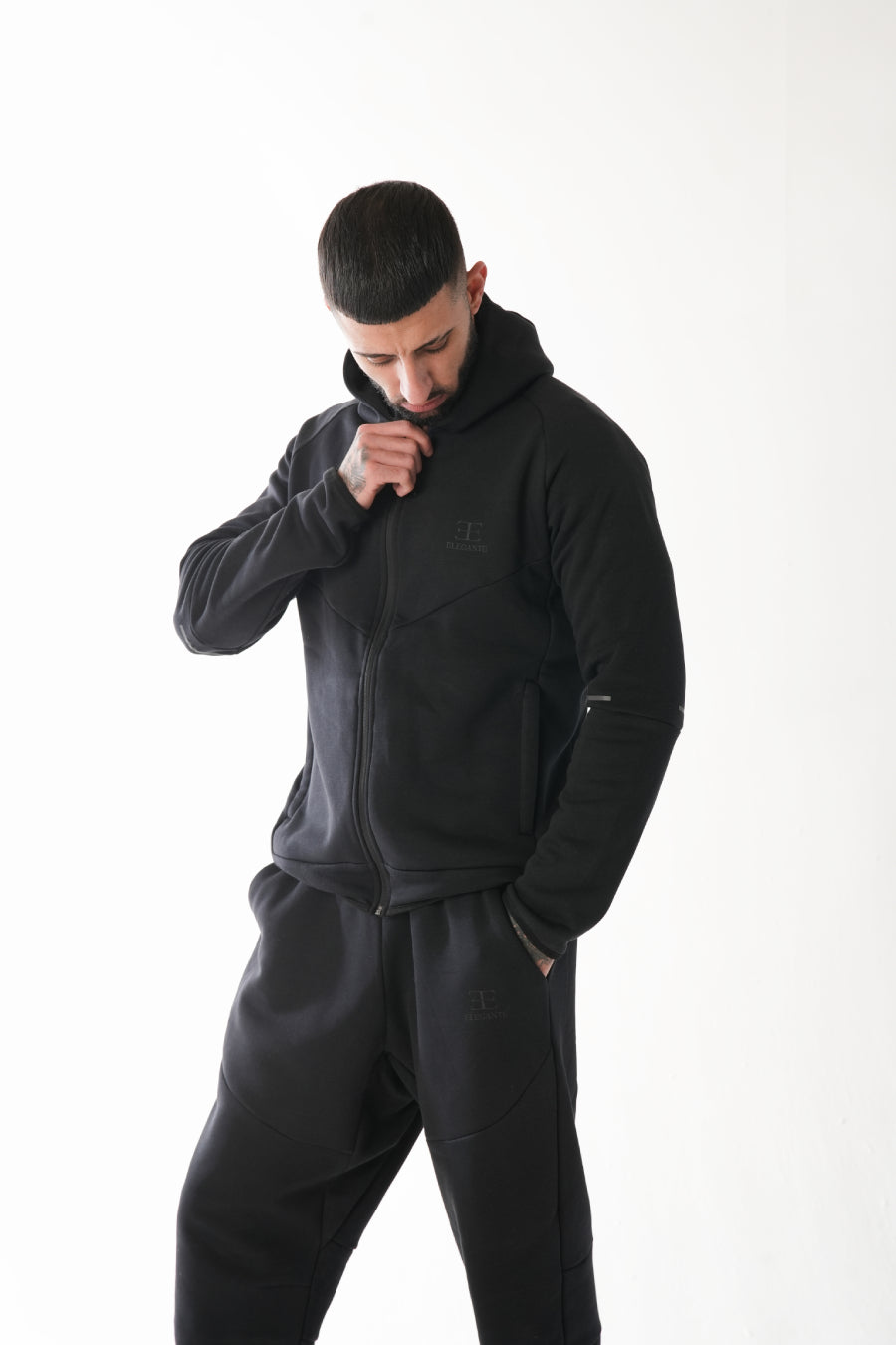 Man wearing a black tracksuit on a white background