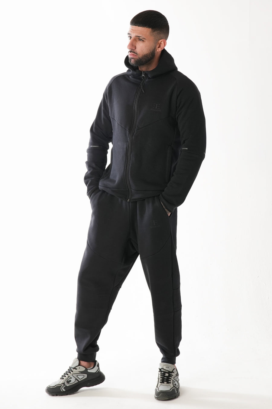 Man wearing a black tracksuit on a white background