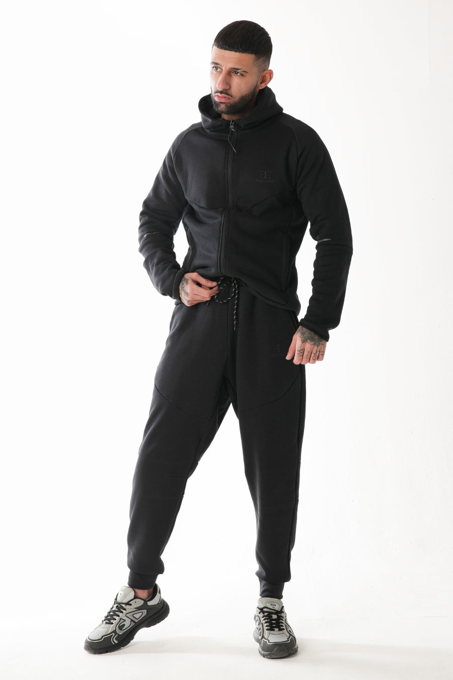 Man wearing a black tracksuit on a white background