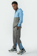 man wearing a blue and gray tracksuit on a white background