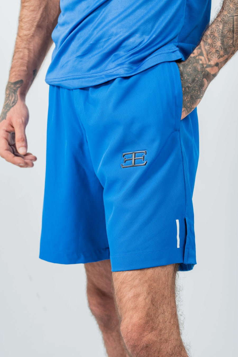 man wearing Blue athletic shorts with a logo on a white background