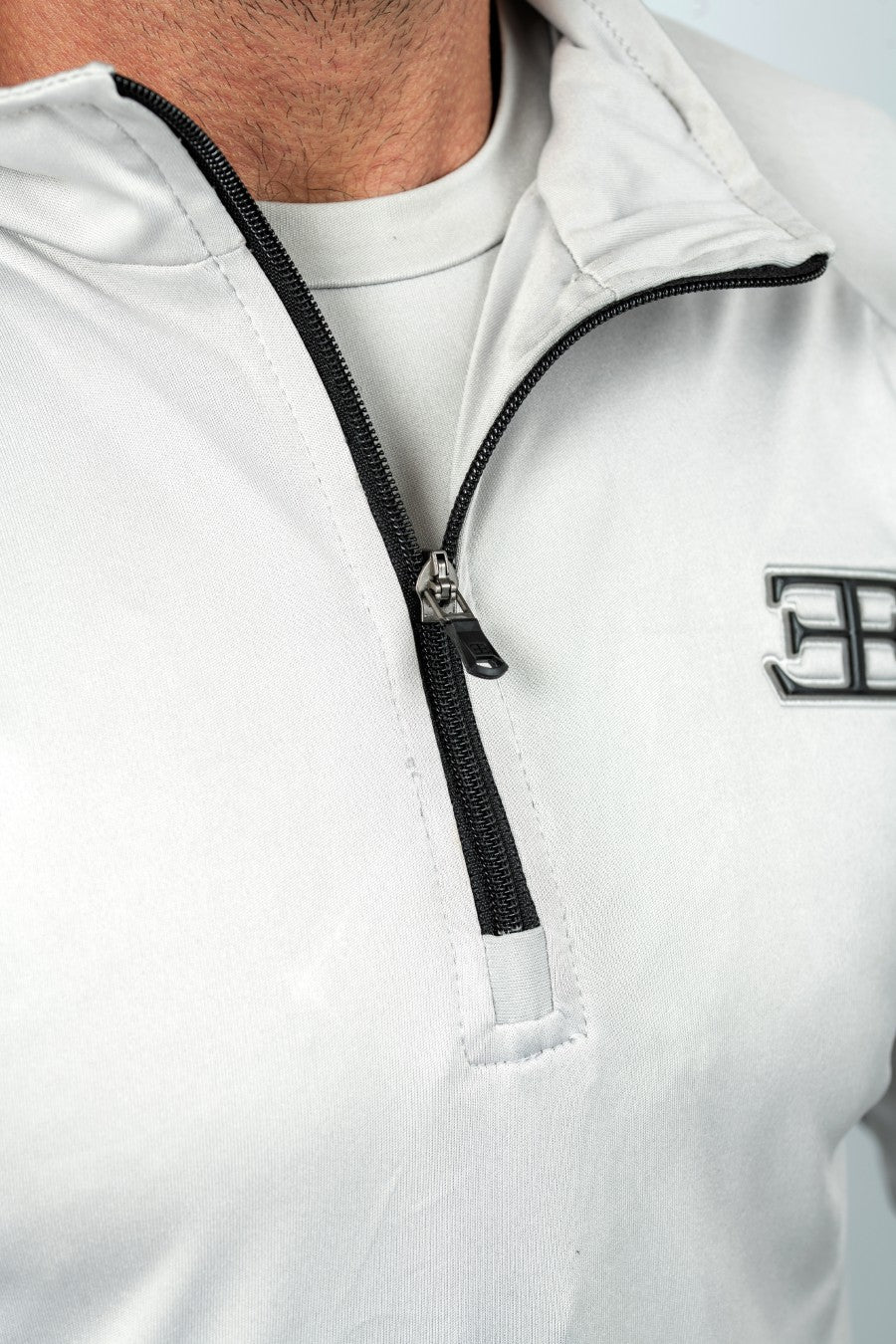 light grey half-zip sweatshirt top with black zipper and elegante logo on a white background
