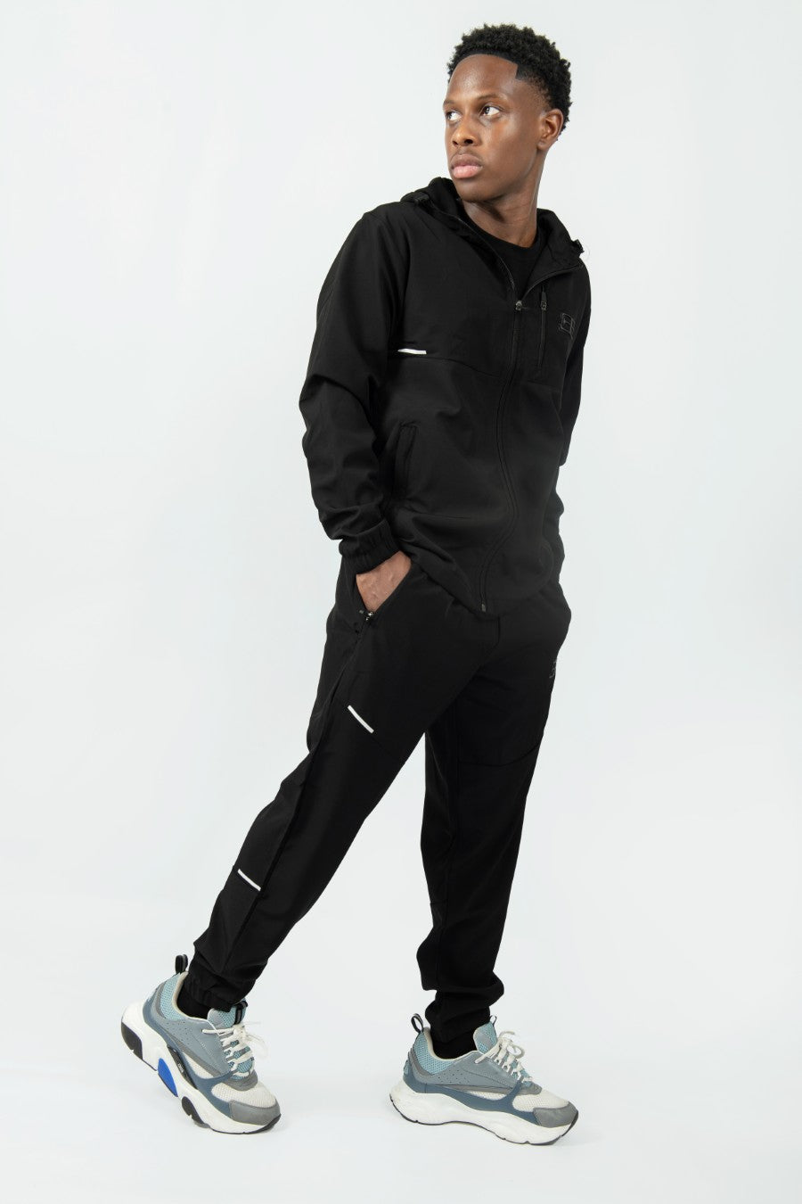 man wearing a black tracksuit with on a white background