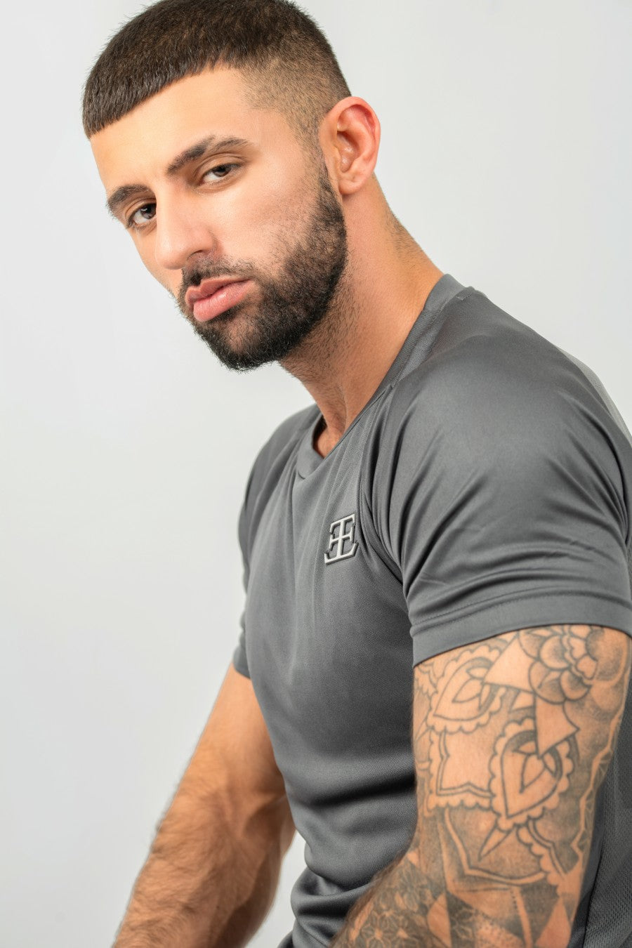 man wearing steel grey tshirt with elegante logo on chest