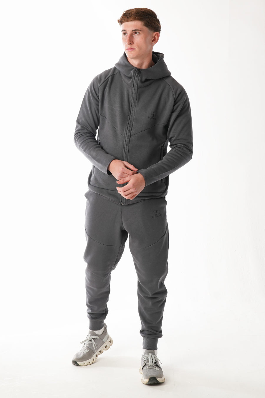 Man wearing a gray tracksuit on a white background