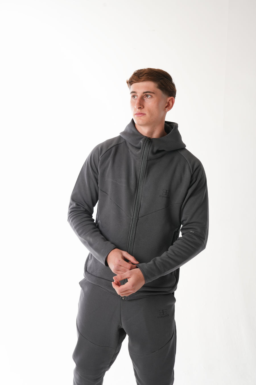 Man wearing a gray hoodie and pants on a white background