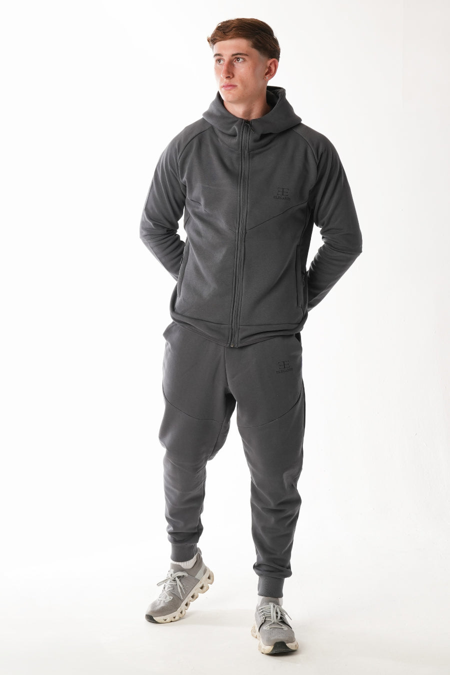 Man wearing a gray tracksuit on a white background