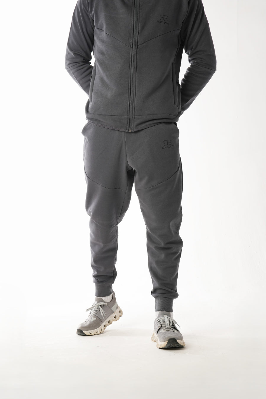 Person wearing a gray tracksuit on a white background