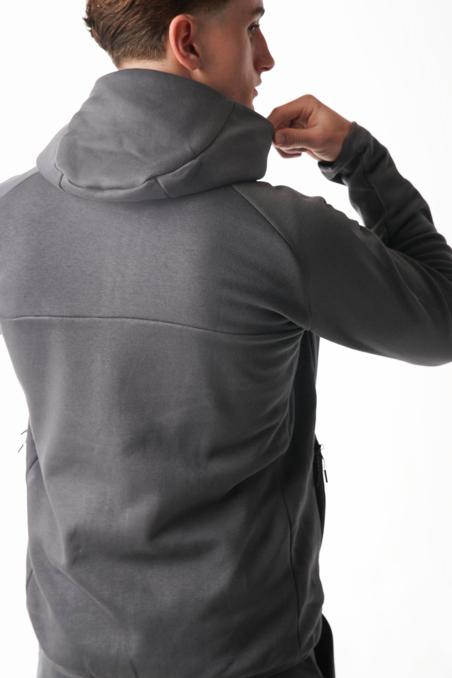 Person wearing a gray jacket on a white background
