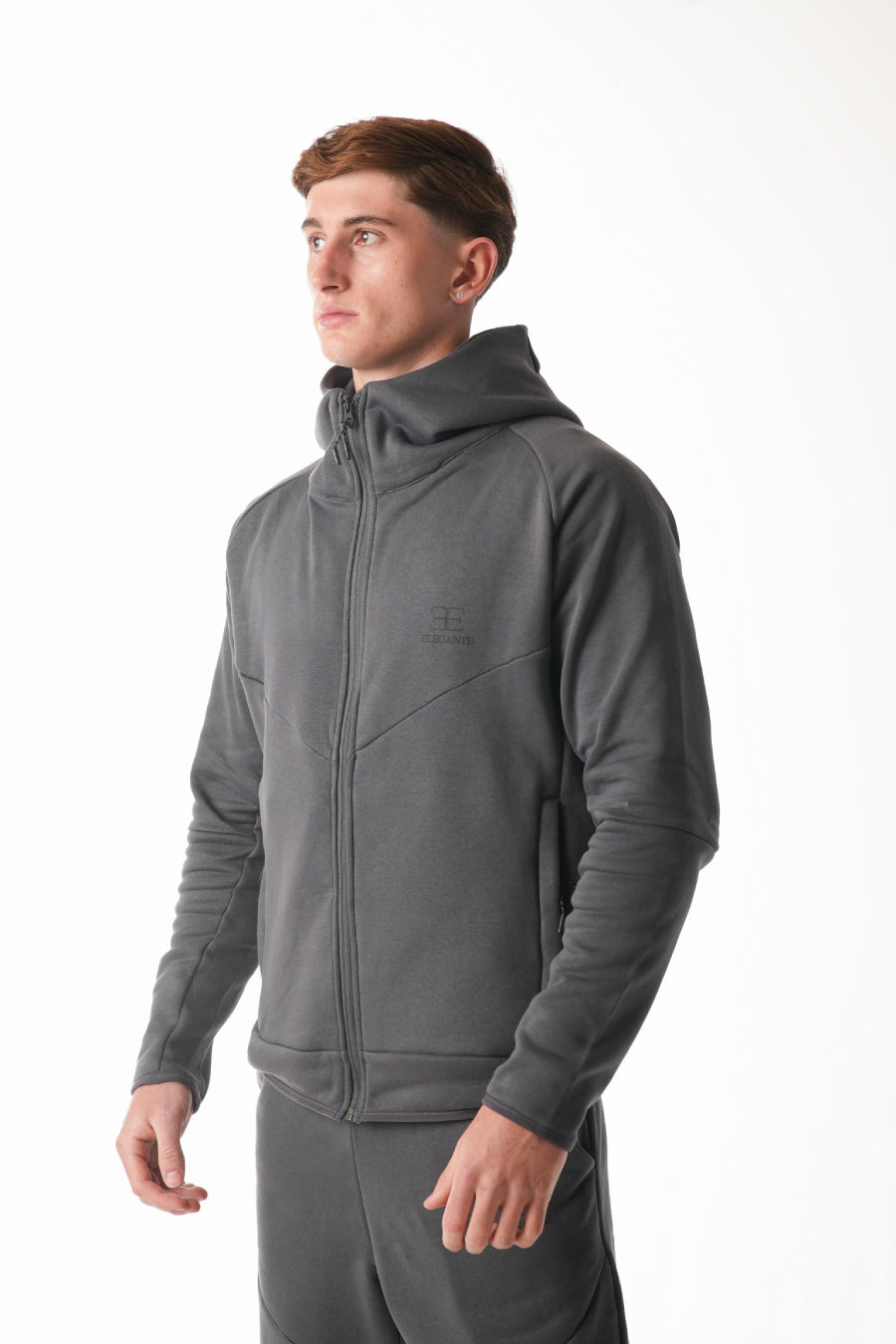 Man wearing a gray tracksuit on a white background