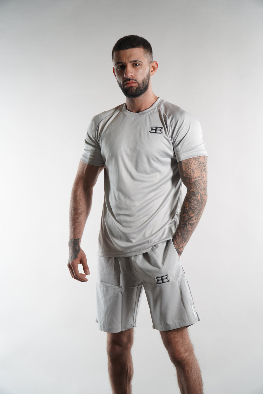 man wearing Elegante brand Silver Grey Gym Shorts and tshirt on white background