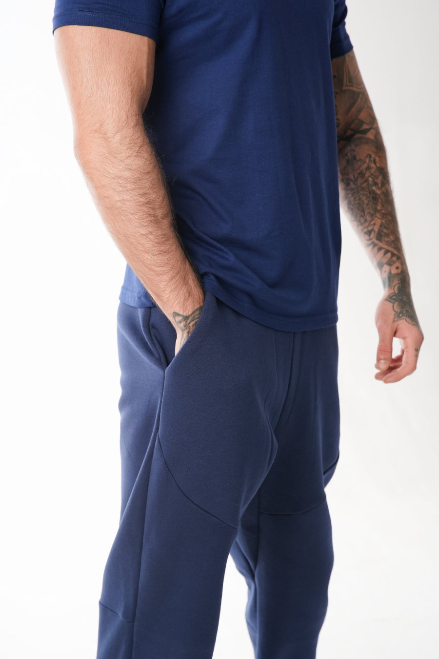 Man wearing a navy blue tracksuit on a white background