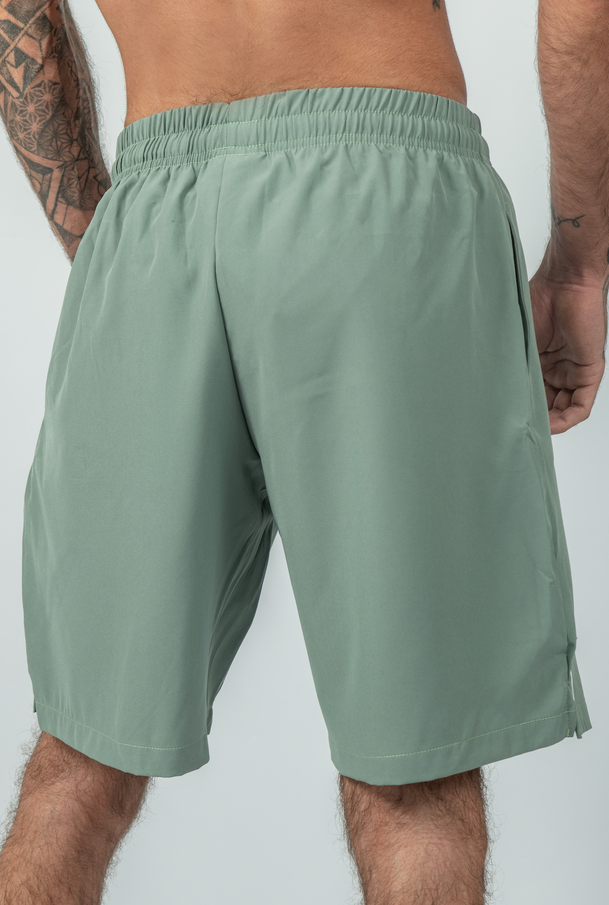 Person wearing light green shorts on a plain background