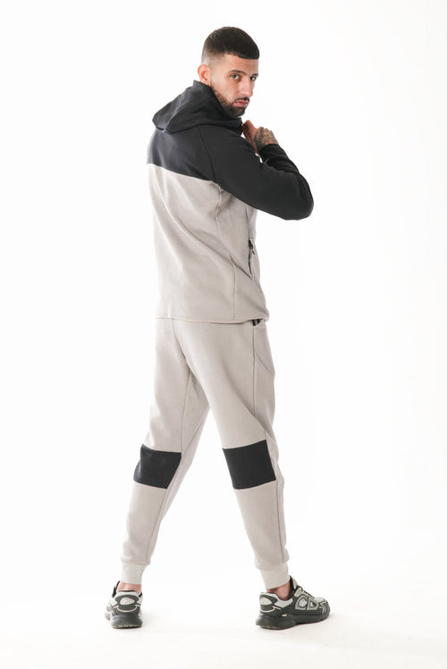 Man wearing a gray and black tracksuit on a white background