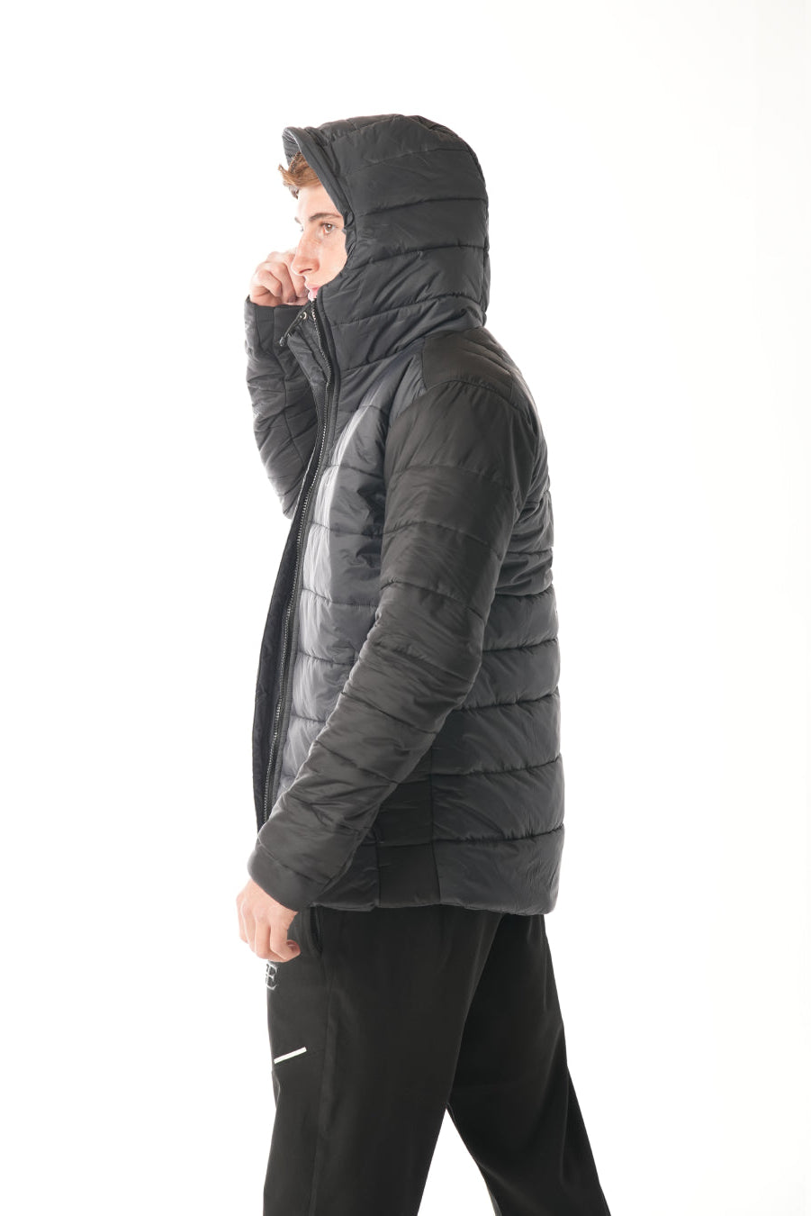 Person wearing a black puffer jacket on a white background