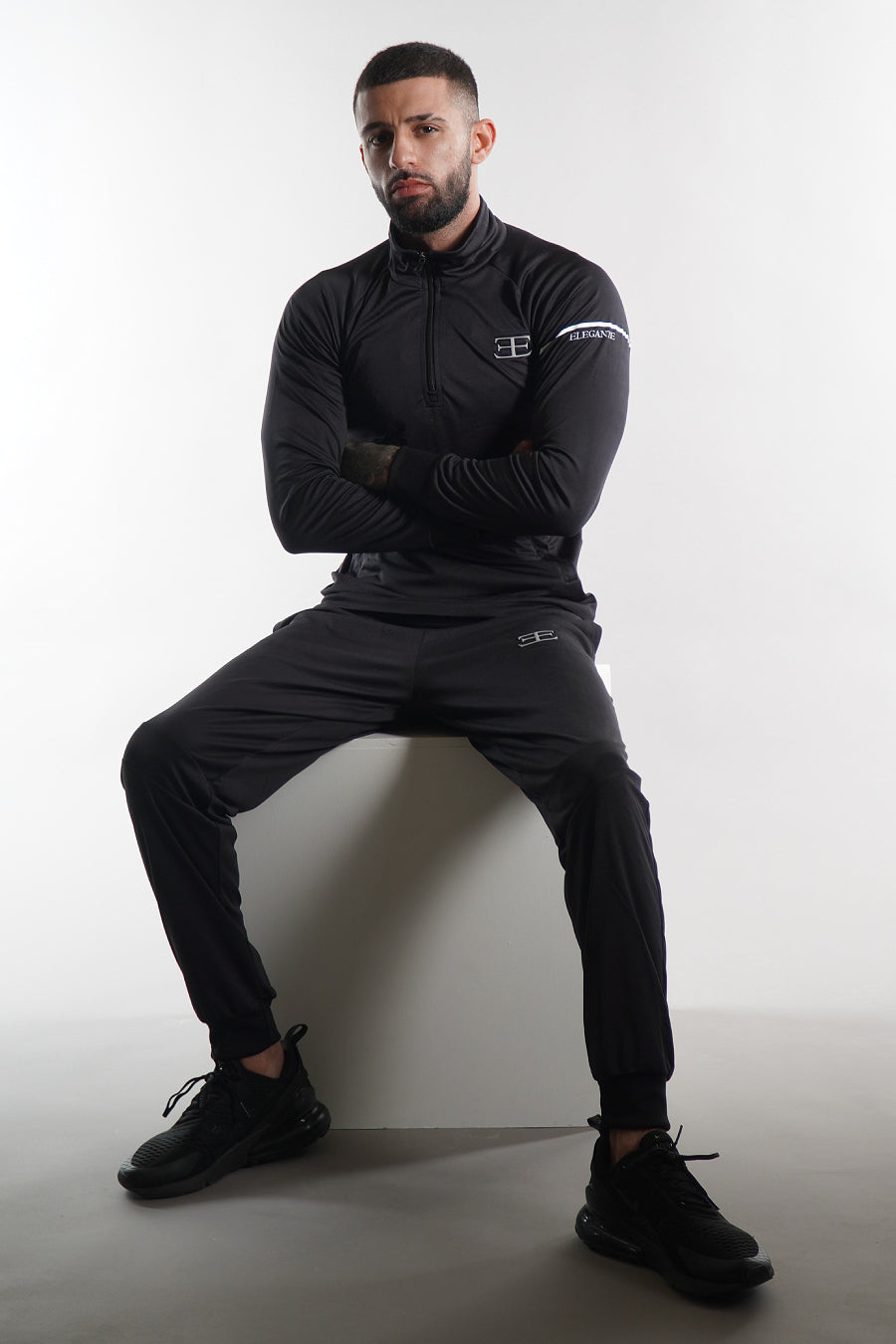 Men's Elegante black tracksuit top and joggers, sportswear set on white background