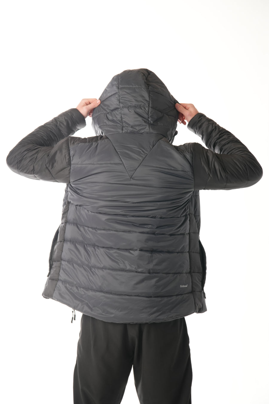 Person wearing a black puffer jacket on a white background