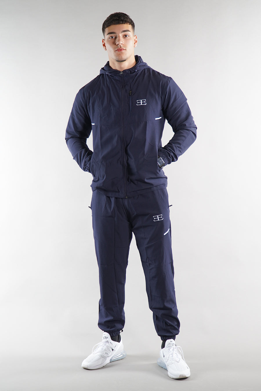 Man wearing a navy tracksuit with a elegante on a white background