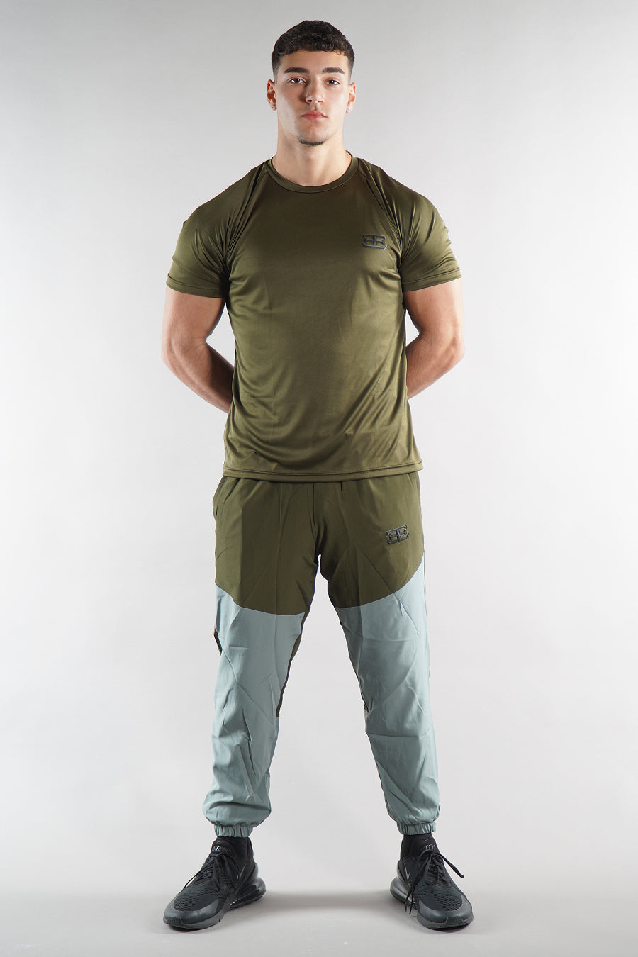 Man wearing a green gym outfit on a white background