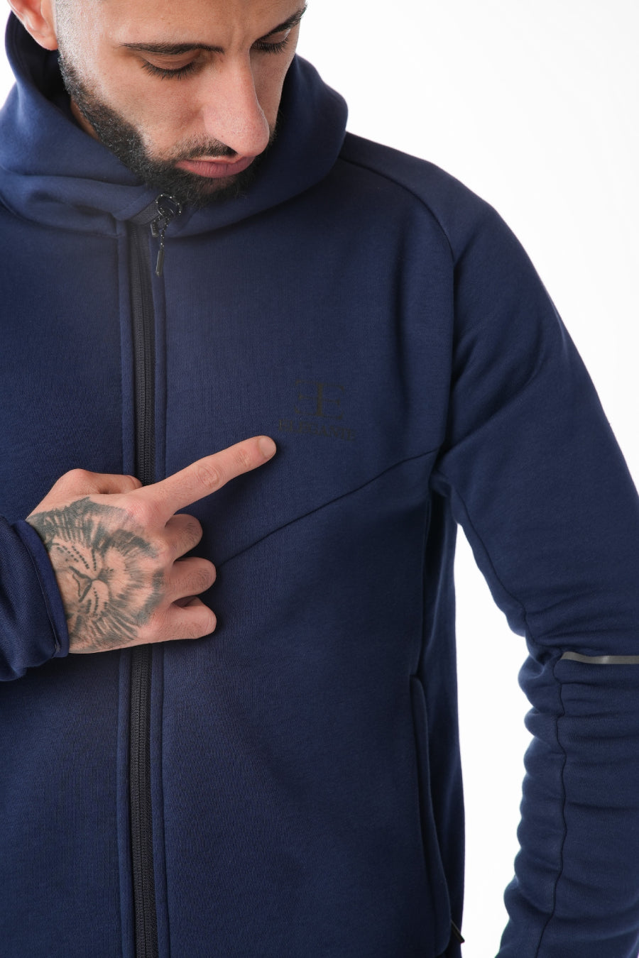 Man wearing a navy blue tracksuit on a white background